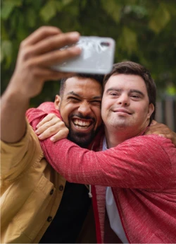 Two guys hugging, smiling and taking a selfie